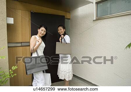 Stock Photo - Mother and daughter coming home from shopping. Fotosearch