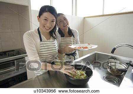 Mother and daughter cooking in kitchen View Large Photo Image Stock Photograph - Mother and daughter cooking in kitchen. Fotosearch