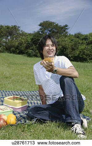 A young man eating hot dog View Large Photo Image Stock Image - A young man eating hot dog. Fotosearch