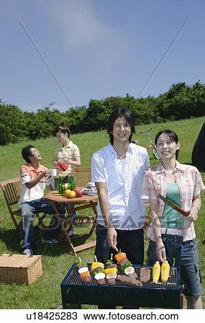Four young people enjoying barbecue View Large Photo Image Stock Image - Four young people enjoying barbecue. Fotosearch