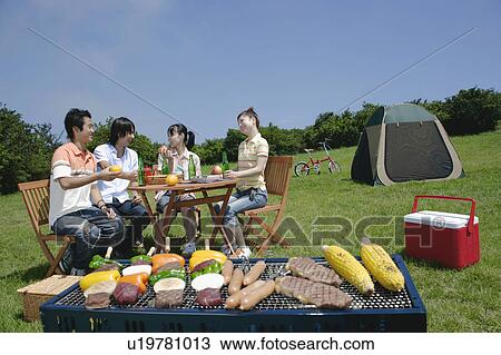 Four young people enjoying barbecue View Large Photo Image Stock Image - Four young people enjoying barbecue. Fotosearch