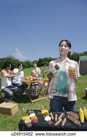 Four young people enjoying barbecue View Large Photo Image Stock Image - Four young people enjoying barbecue. Fotosearch