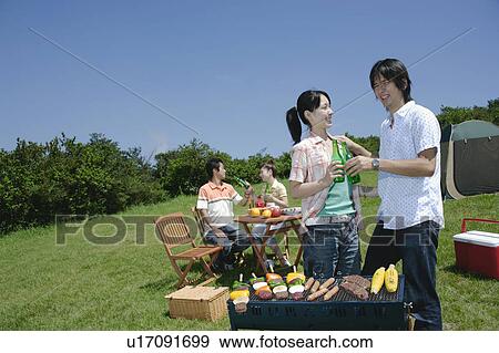 Stock Photo - Four young people enjoying barbecue. Fotosearch