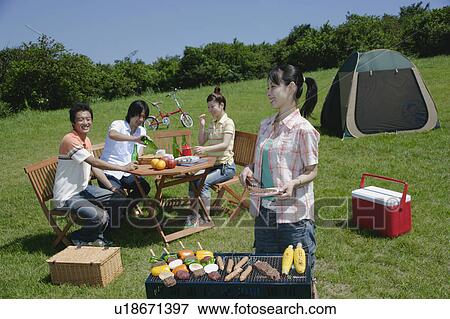 Stock Photo - Four young people enjoying barbecue. Fotosearch