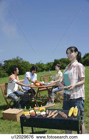 Four young people enjoying barbecue View Large Photo Image Stock Photograph - Four young people enjoying barbecue. Fotosearch