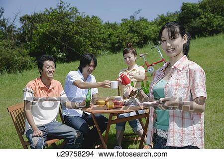 Picture - Four young people enjoying picnic. Fotosearch