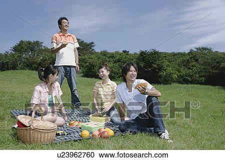 Four young people enjoying picnic View Large Photo Image Stock Image - Four young people enjoying picnic. Fotosearch