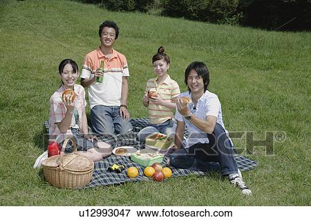 Stock Photo - Four young people enjoying picnic. Fotosearch