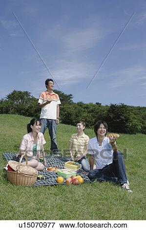Stock Photo - Four young people enjoying picnic. Fotosearch