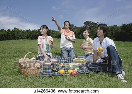 Stock Photograph - Four young people enjoying picnic. Fotosearch