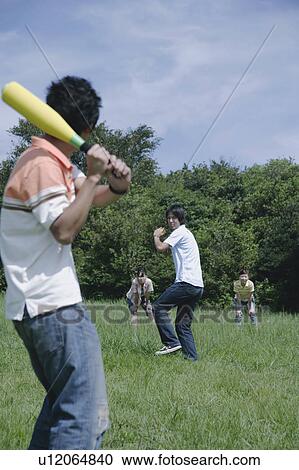 Stock Image - Four young people playing baseball. Fotosearch