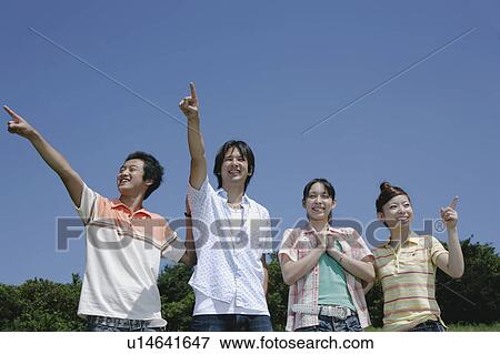 Stock Photo - Four young people pointing directions. Fotosearch