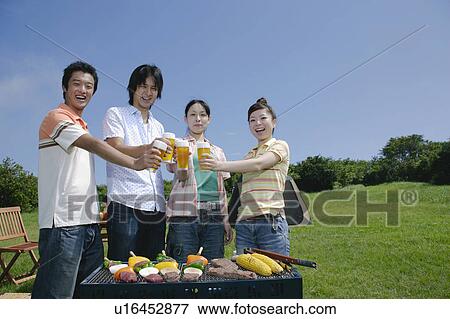 Four young people toasting with beer View Large Photo Image Stock Photo - Four young people toasting with beer. Fotosearch