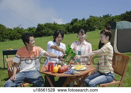 Four young people toasting with beer bottle View Large Photo Image Stock Photo - Four young people toasting with beer bottle. Fotosearch