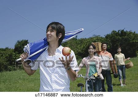 Stock Photo - Four young people walking with picnic baskets. Fotosearch