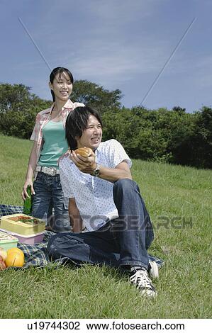 Young couple enjoying picnic View Large Photo Image Stock Image - Young couple enjoying picnic. Fotosearch