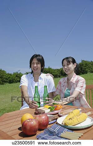 Young couple enjoying picnic View Large Photo Image Stock Image - Young couple enjoying picnic. Fotosearch