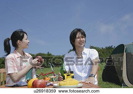 Stock Photo - Young couple enjoying picnic. Fotosearch