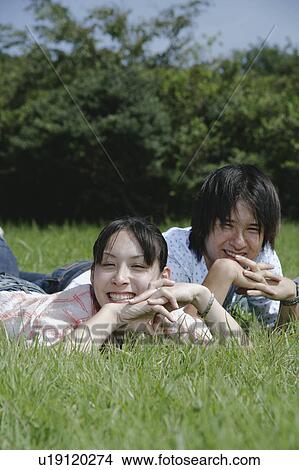 Picture - Young couple lying on grass. Fotosearch