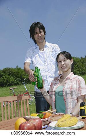 Young couple toasting with beer bottles View Large Photo Image Picture - Young couple toasting with beer bottles. Fotosearch