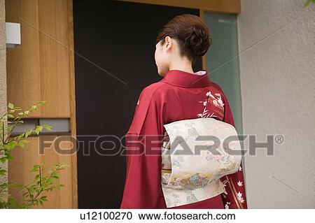 A young woman wearing kimono standing in front of door View Large Photo Image Stock Image - A young woman wearing kimono standing in front of door. Fotosearch