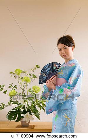 Picture - A young woman wearing yukata holding folding fan. Fotosearch