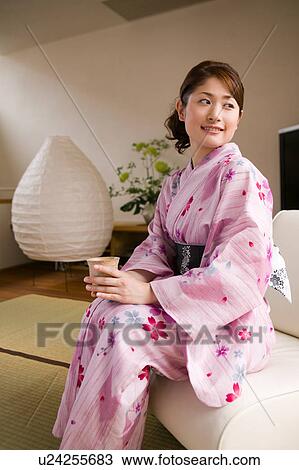 A young woman wearing yukata sitting on sofa View Large Photo Image Stock Image - A young woman wearing yukata sitting on sofa. Fotosearch