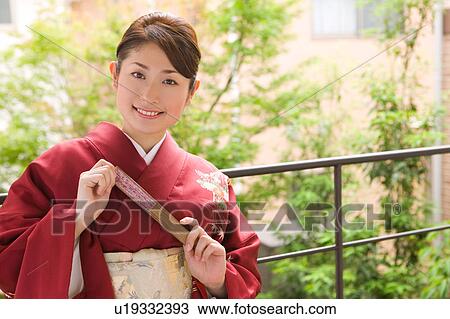 Stock Image - Portrait of a young woman wearing kimono. Fotosearch