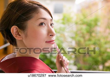 Stock Photo - Portrait of a young woman wearing kimono. Fotosearch