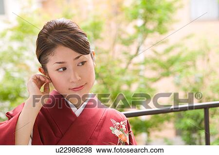 Stock Photo - Portrait of a young woman wearing kimono. Fotosearch
