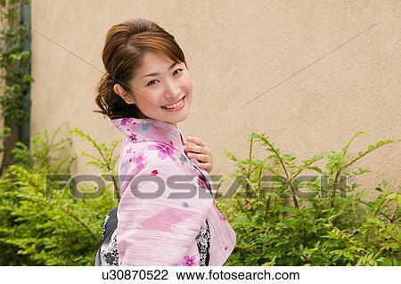 Stock Image - Portrait of a young woman wearing yukata. Fotosearch