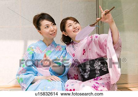 Picture - Two young women wearing yukata sitting on porch. Fotosearch