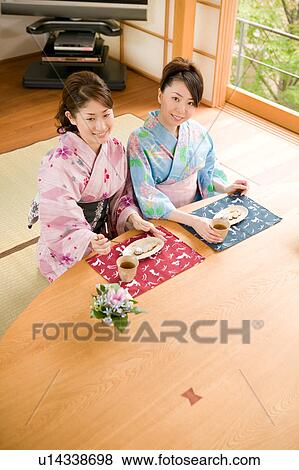 Two young women wearing yukata sitting View Large Photo Image Stock Photo - Two young women wearing yukata sitting. Fotosearch