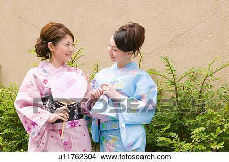 Two young women wearing yukata talking View Large Photo Image Picture - Two young women wearing yukata talking. Fotosearch