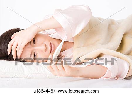 A woman looking at thermometer View Large Photo Image Stock Photo - A woman looking at thermometer. Fotosearch