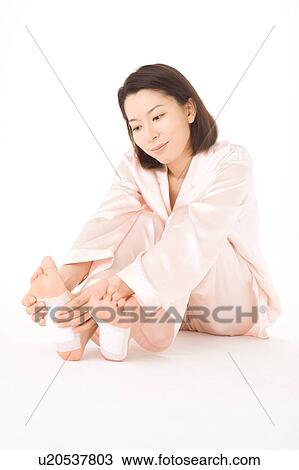 A woman putting detox pads on her feet View Large Photo Image Stock Image - A woman putting detox pads on her feet. Fotosearch