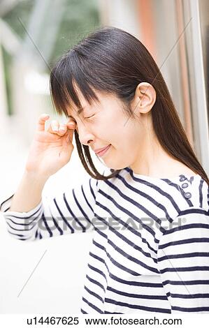 Stock Photography - A woman rubbing her eyes. Fotosearch
