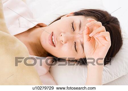 Stock Photo - A woman suffering from cold. Fotosearch