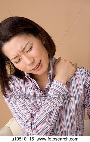 A woman suffering from pain in shoulder View Large Photo Image Stock Photography - A woman suffering from pain in shoulder. Fotosearch