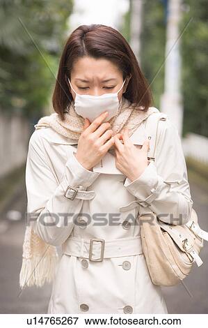 Stock Photo - A woman wearing mask. Fotosearch