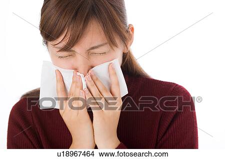 A young woman blowing nose on tissue View Large Photo Image Picture - A young woman blowing nose on tissue. Fotosearch