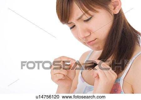 A young woman looking at hair View Large Photo Image Stock Image - A young woman looking at hair. Fotosearch