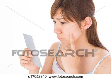 A young woman looking at pimple on her face View Large Photo Image Stock Image - A young woman looking at pimple on her face. Fotosearch