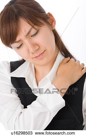 Stock Image - A young woman massaging shoulder. Fotosearch