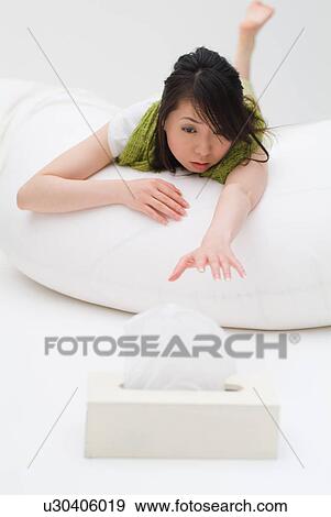 A young woman reaching to tissue box View Large Photo Image Stock Photo - A young woman reaching to tissue box. Fotosearch
