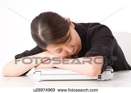 A Young Woman Sleeping At Her Desk Stock Photo U28974969