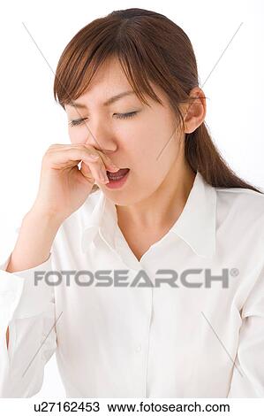 Stock Image - A young woman sneezing. Fotosearch