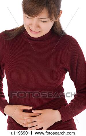 Stock Image - A young woman suffering from abdominal pain. Fotosearch