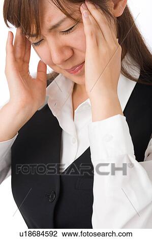 Stock Image - A young woman suffering from headache. Fotosearch