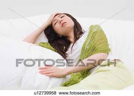 Stock Photo - A young woman suffering from headache. Fotosearch